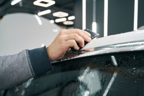 Pro Tint LLC technician applying paint protection film on car glass