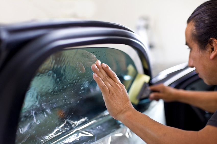 A technician is applying car window tint film by Pro Tint LLC in Palm Coast, FL